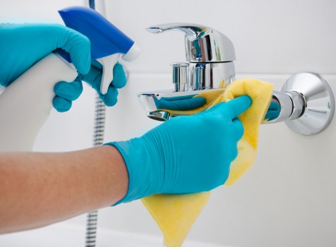 Cleaner tidying a modern apartment kitchen in Harrow